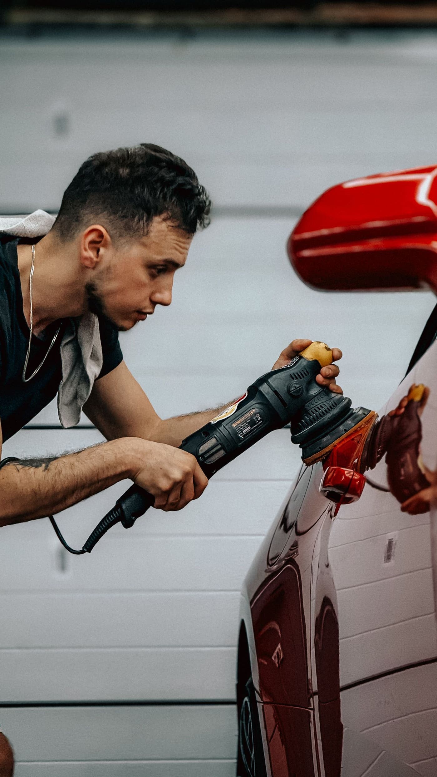 Detailer machine polishing a red car